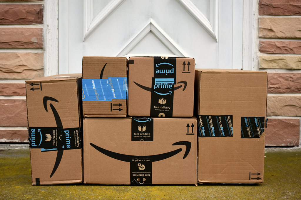 several Amazon Prime boxes piled up at a door