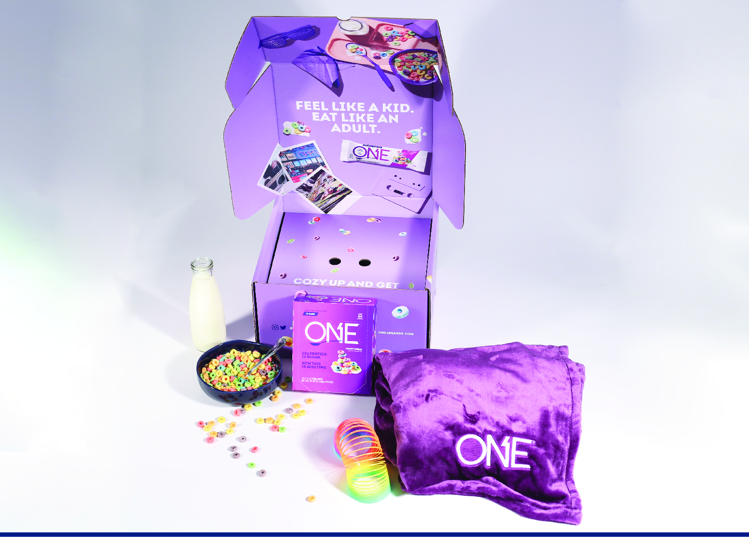 a purple blanket, slinky and bowl of cereal next to a purple box with the brand "One" bars on it